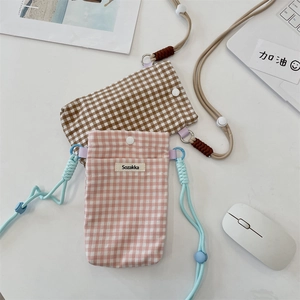 Détail de petites pochettes de téléphone en tissu à carreaux avec cordons rose et marron