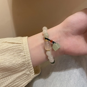 Bracelet ethnique en perles de jade et agate avec pendentif lotus sur poignet femme