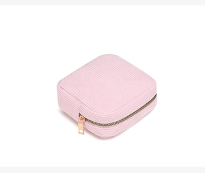 Detailed view of pink corduroy makeup bag with elegant gold zipper on white background