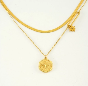 Close-up of double-layer gold snake chain necklace with star and coin pendants