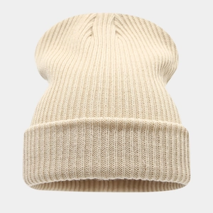 Gros plan sur la texture en maille côtelée épaisse et le tissu beige doux de ce bonnet d'hiver