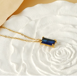 Detail of 18K gold stainless steel necklace with rectangular blue zircon gemstone pendant