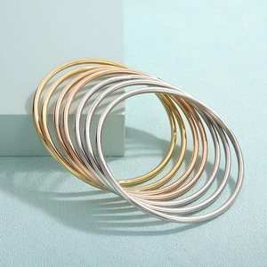 Set of seven multi-tone titanium steel stackable round bangle bracelets in gold, silver and rose gold