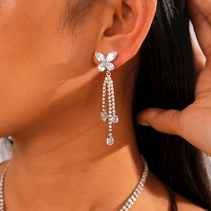 Close-up of silver butterfly tassel earrings with zircon waterdrop pendants on model