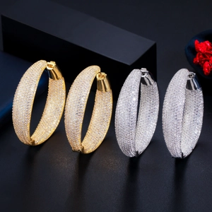 Macro detail of thick gold and silver hoops featuring micro-pave cubic zirconia crystals