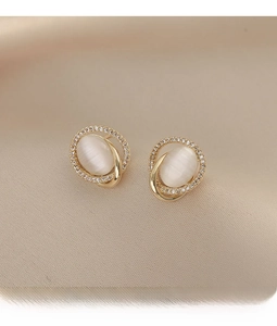 Macro shot of oval cat eye stone stud earrings with gold finish and zircon stones