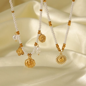 Detailed shot of pearl necklaces with sunflower pendants on luxurious golden silk fabric
