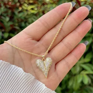 Close-up of 18K gold heart pendant with pavé cubic zirconia on a twisted rope chain
