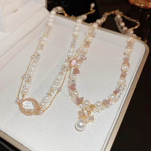 Detail view of French vintage pearl necklaces with crystals in a beige jewelry box