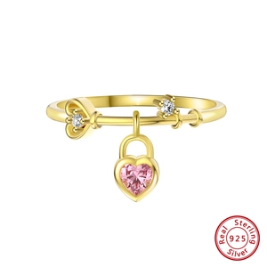 Detail of 925 sterling silver ring with pink heart gem and golden heart lock pendant