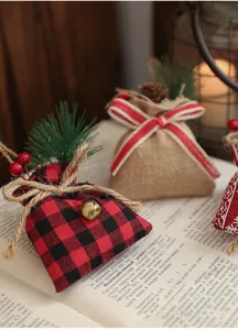 Detail of burlap Christmas gift bags with pine needles, bells and red berries decor