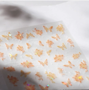 Macro view of 3D laser gold butterfly nail stickers with holographic floral patterns