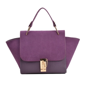Purple winged handbag with crocodile embossing and suede paneling on white background
