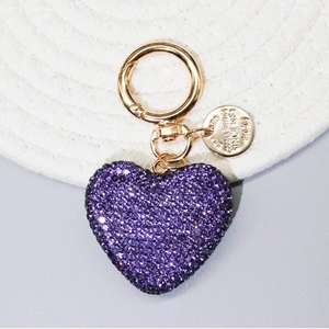 Dettaglio macro del portachiavi a cuore con strass viola e gancio in lega dorata