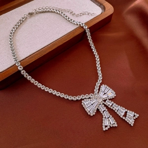 Détail du collier avec pendentif nœud étincelant et pierres de zircon sur chaîne argentée