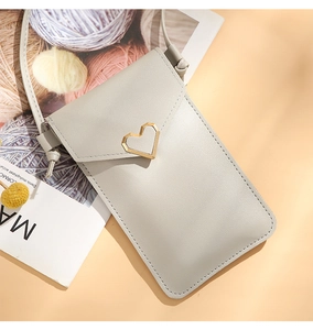 Detail of grey PU leather phone bag with golden heart buckle and slim crossbody strap
