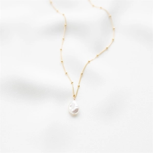 Long gold satellite chain necklace featuring irregular baroque freshwater pearl pendant