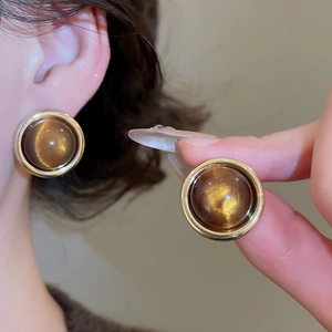 Detailed view of 18k gold plated tiger eye earrings with retro geometric round design