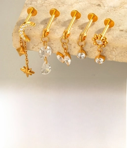 Detailed view of 1.2x10mm gold titanium lip rings set with cubic zirconia pendants