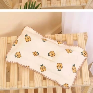 Dettaglio del cuscino in cotone per neonati con stampa di tigre e pizzo marrone