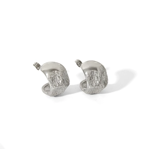 Gros plan de boucles d'oreilles argentées en C avec texture de lave et fermoir tige