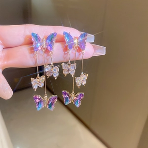 Detailed macro of purple butterfly tassel earrings featuring three-layered gradient crystals