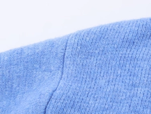 Primo piano del tessuto a maglia azzurro che mostra trama verticale e cuciture