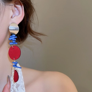 Vue latérale d'un mannequin portant de longues boucles d'oreilles rouges et bleues design