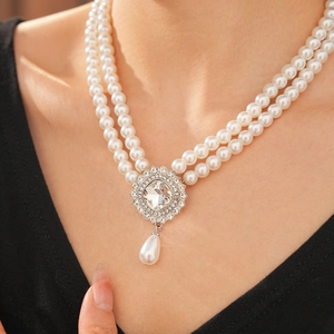 Macro detail of double-layer pearl necklace with sparkling rhinestone teardrop pendant