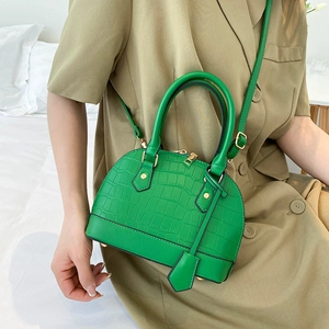 Emerald green shell-shaped crossbody bag with crocodile embossed leather and gold hardware