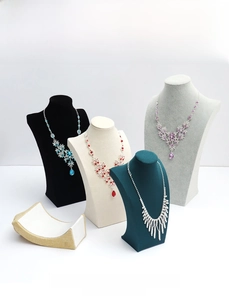Detailed view of four elegant necklaces displayed on premium velvet bust stands in various colors