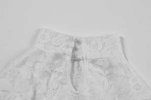 Close-up of white lace dress featuring high collar and back opening with three round buttons