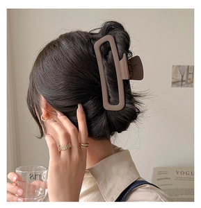 Detail view of large dark brown matte rectangular shark hair claw clip for thick hair