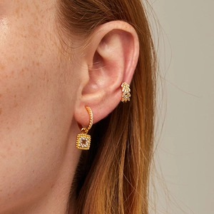 Close-up of gold square hoop earrings and ear cuff with micro-pave zircons on model
