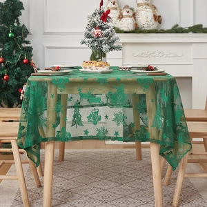 Detailaufnahme der grünen Weihnachts-Spitzentischdecke mit Rentier- und Schneeflockenmustern