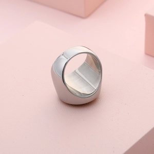 Polished silver stainless steel thick dome ring on minimalist pink background