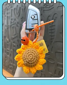 Detailed view of handcrafted crochet sunflower keychain with vibrant orange lanyard and bell