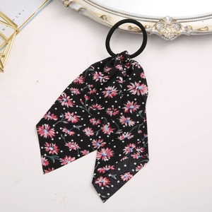 Detail of floral scrunchie with ribbons, vintage black fabric with red flowers and white dots