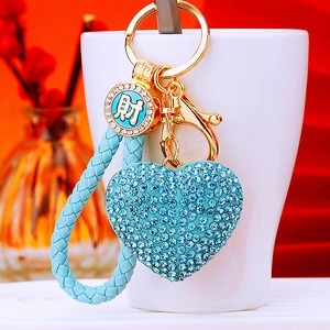Blue rhinestone heart keychain with braided leather strap and gold lucky charm