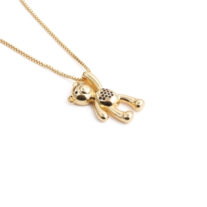 Macro view of gold bear pendant with black zircon heart on a fine box chain necklace