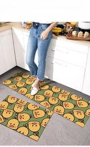 Detail view of two-piece set kitchen mats with yellow cartoon duck pattern on green