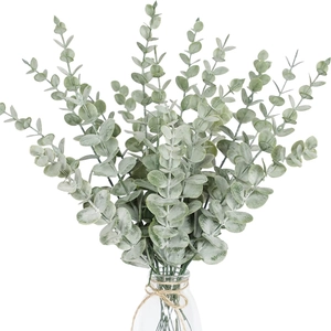 Close-up of frosted grey-green artificial eucalyptus leaves in a clear glass bottle