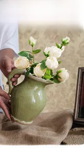 Primo piano di un vaso vintage in ceramica con smalto cracklé e manico decorativo