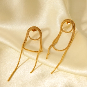 Detailansicht der goldenen Quastenohrringe mit Schlangenkette auf weicher Seide