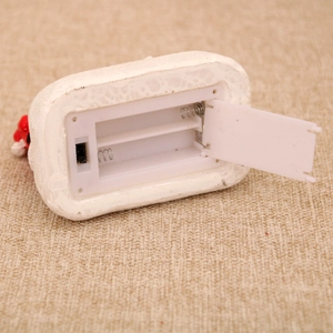 Détail du compartiment à piles et de l'interrupteur pour maison de Noël lumineuse