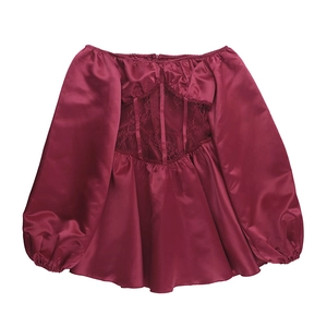 Détail du haut en satin bordeaux avec manches bouffantes et empiècement en dentelle fine