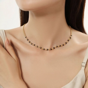 Detail of gold enamel heart link chain necklace worn on professional model's neck