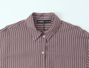 Detailed close-up of a striped cotton shirt collar with buttons and internal brand label