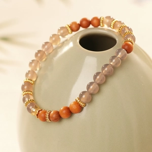 Détail de perles en bois de santal et agate sur un vase en céramique décoratif