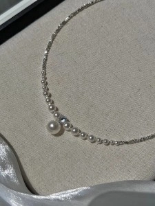 Detailed view of elegant pearl pendant with cubic zirconia on silver chain necklace